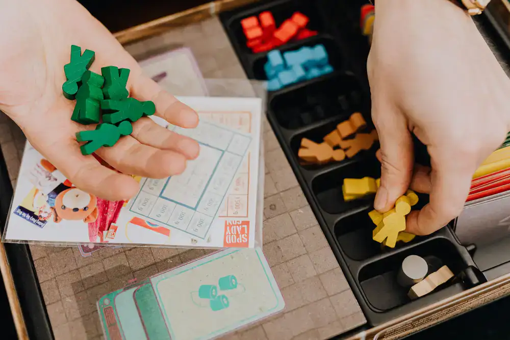 Players engaged in an original Meeple Forge board game prototype
