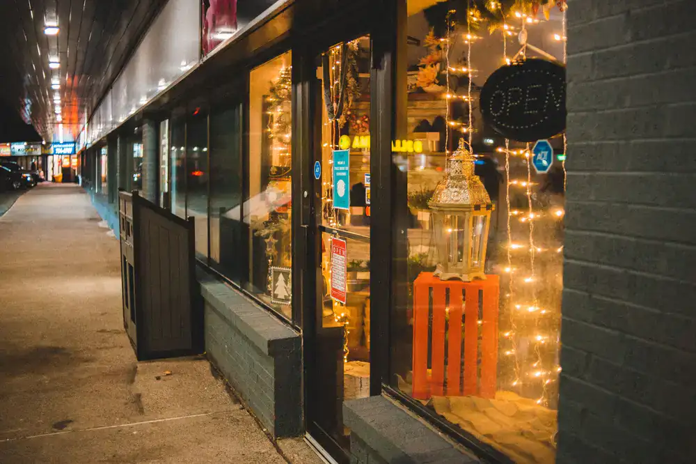 Warm glowing windows of a board game shop viewed from the street at dusk