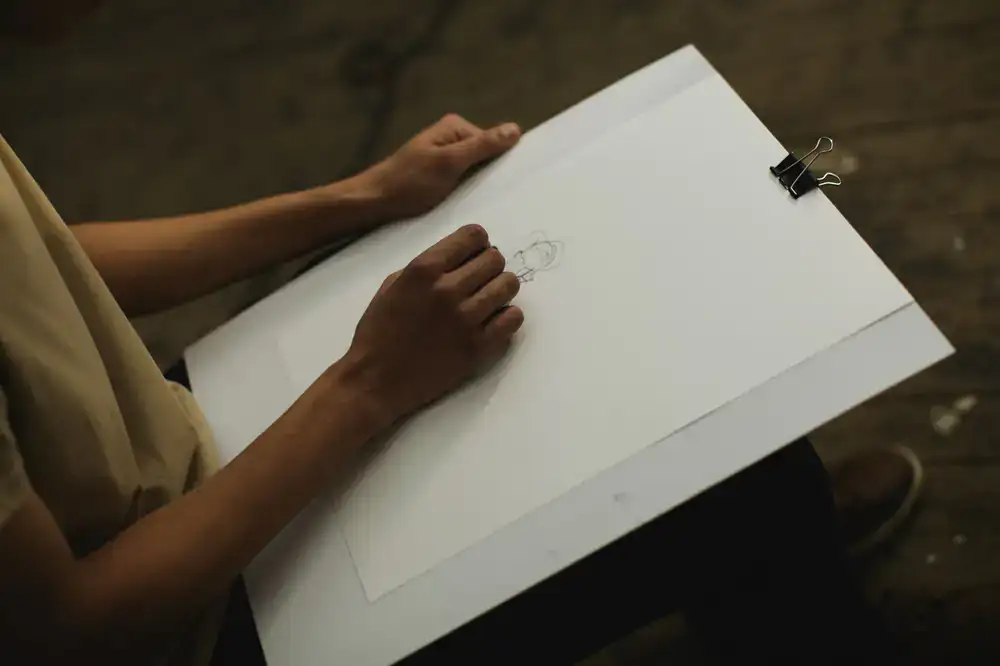 Designer sketching game board mechanics on a large grid paper pad